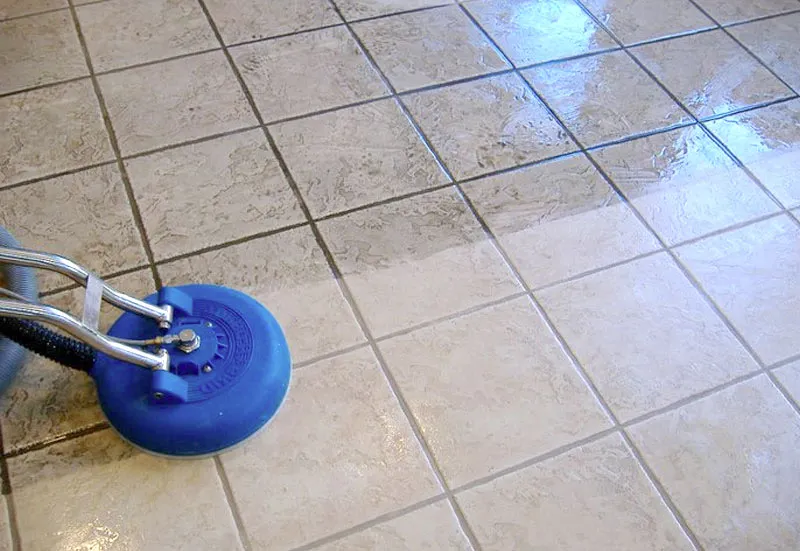 A floor machine cleaning tile, with the grout lines coming back to a lighter color