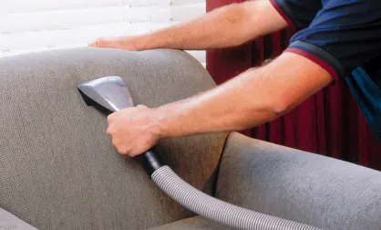 A Silvia Clean technician steam-cleaning an upholstered couch